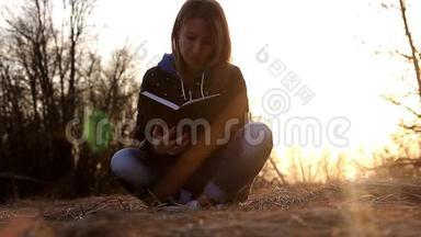美丽的少女，坐在公园里的一片落叶上，看书，晚霞<strong>淡淡</strong>.. 概念女孩自由职业者
